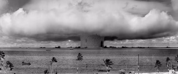 grayscale photo of explosion on the beach