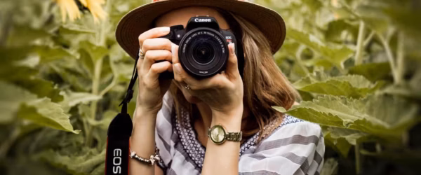 selective focus photography of woman holding dslr camera