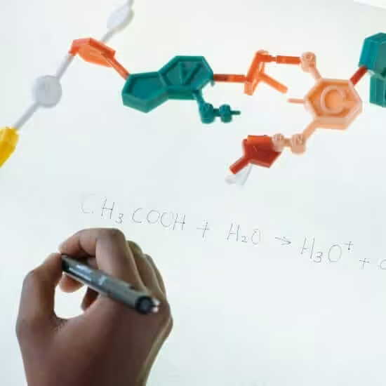 crop ethnic clever student writing formula after analysis of molecule model in university