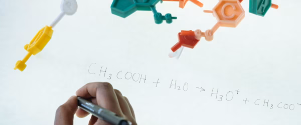 crop ethnic clever student writing formula after analysis of molecule model in university