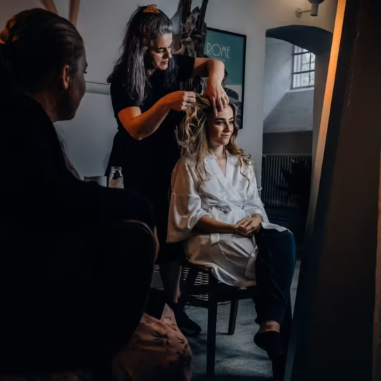hairstylist fixing her client s hair