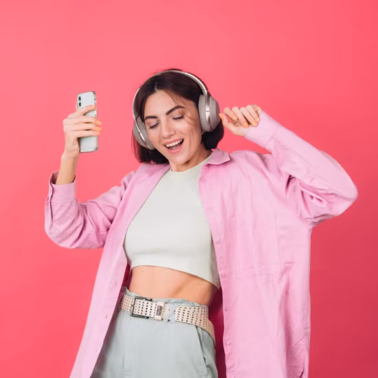 happy positive woman headphones pink red wall
