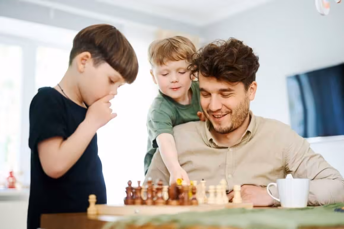 Father teaching sons how to play chess