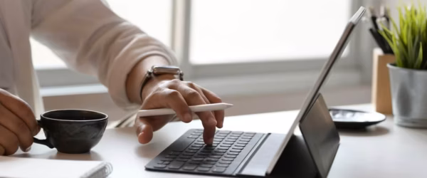 Person typing on tablet with coffee