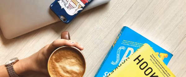 person holding brown ceramic coffee mug