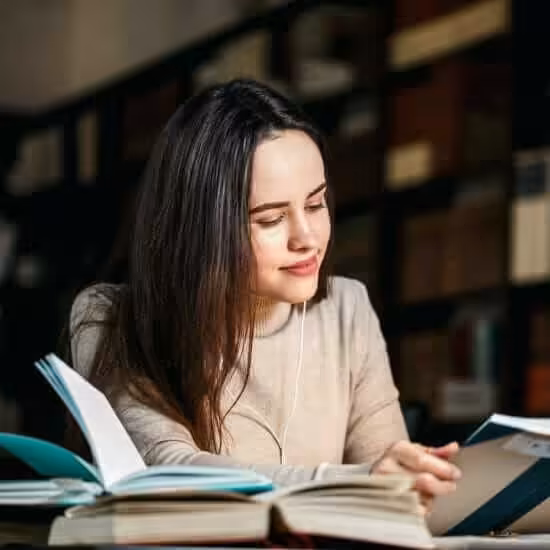 brunette woman reading book table with lamp