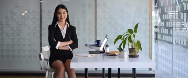 Businesswoman sitting confidently at desk.
