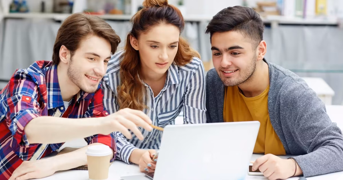 Three students collaborating on laptop