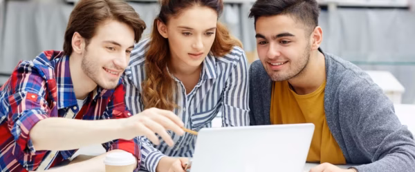 Three students collaborating on laptop