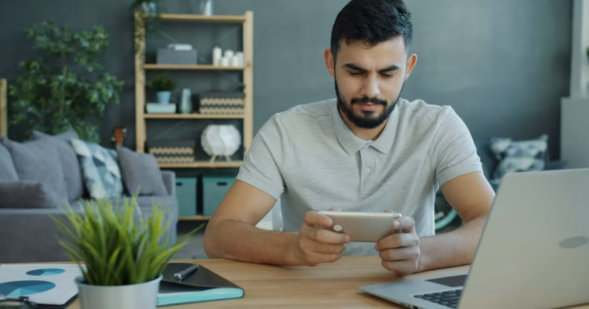 Happy Moddle Eastern man is playing video game