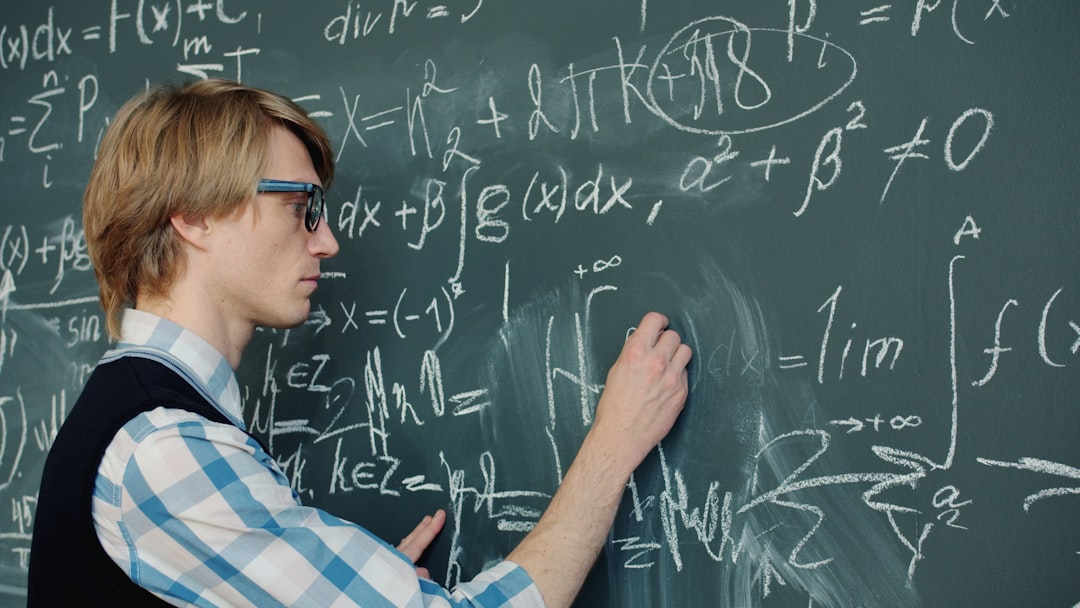 Mathematician writing prime number formulas on chalkboard