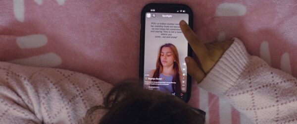 Young person on a phone watching short-form digital entertainment